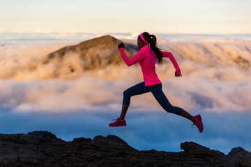 Wall Mural - Fitness run athlete runner girl running at sunset on mountain trail. Scenic landscape cold clouds weather. Woman sprinting training cardio in nature outdoors.