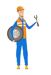 Wall Mural - Young caucasian mechanic with tyre and spanner.