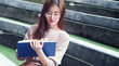 © Bluehousestudio - Asian beautiful woman wearing glasses writes a note on stairs