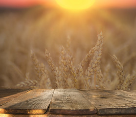 Wall Mural - wood board table in front of field of wheat on sunset light. Ready for product display montages