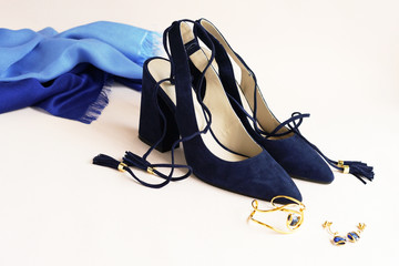Beautiful woman fashion blue high heel shoes, jewelry and silk scarf on light background
