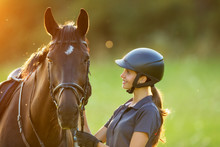 Young Woman Rider With Her Horse In Evening Sunset Light