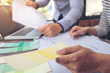 © Freedomz - Two colleagues interior Creative creativity graphic designer working with graphics laptop, blueprint and colour chart at workplace on wooden desk , colour ideas style concept