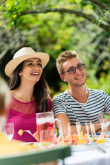 Poster - Group of friends lunching in the garden, focus on a woman