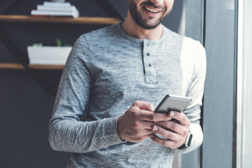 Wall Mural - Cheerful bearded manager is sending message using handset