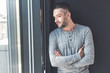 © Yakobchuk Olena - Elegant adult guy is leaning on wall and watching through glass