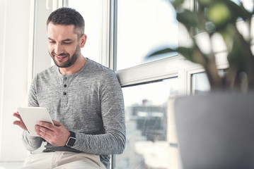 Wall Mural - Joyful successful employee is enjoying modern gadget