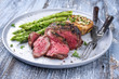 © HLPhoto - Barbecue Wagyu Hüftsteakt mit grünen Spargel und Pilzkappen als close-up auf Teller