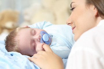 Wall Mural - Mother watching her baby sleeping on bed