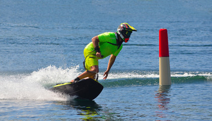 Wall Mural - Male Motosurf Competitor Taking corner at speed creating a lot of spray.