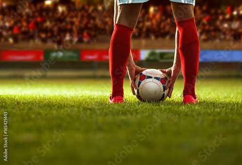 Zdjęcie XXL Gracz piłki nożnej z czerwonymi skarpetami przygotowywa dla bezpłatnego kopnięcia.