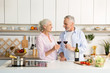 © Drobot Dean - Mature happy loving couple standing at the kitchen drinking wine