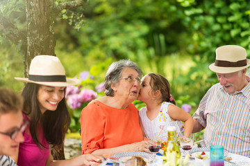 Wall Mural - Three generations family having lunch in the garden