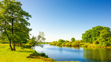 Sommerliche Landschaft mit Wiesen und Fluss