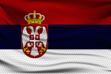 Wall Mural - National flag of Serbia on wavy fabric with a volumetric pattern of hexagons. Vector illustration.