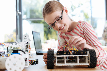 Smiling girl checking intactness of wires