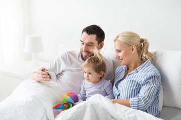 Poster - happy family with smartphone in bed at home