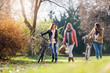 © lordn - Group of smiling college girls in park taking selfie