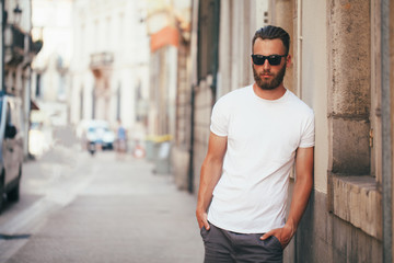 hipster handsome male model with beard wearing white blank t-shirt with space for your logo or desig