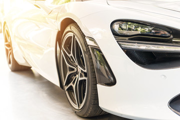 Front of a white sport luxury car in sunset