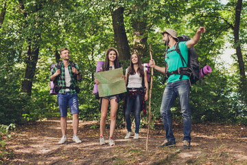 camping, trekking, wild life concept. four best friends are hiking in the spring woods, the guy is s