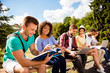 © deagreez - Classmate, international friendship, summer, communication, education and teenage concept. Group of cheerful students teenagers in casual outfits with note books are studying outdoors