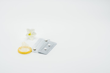 Wall Mural - Two blister pack of emergency contraceptive pills, condom and flower on white background