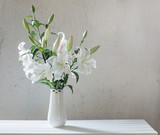 beautiful white lily in vase on background old wall