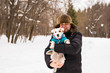 © satura_ - Pet owner, dog, and people concept - Young smiling caucasian man holding Jack Russell terrier outdoor in winter time.