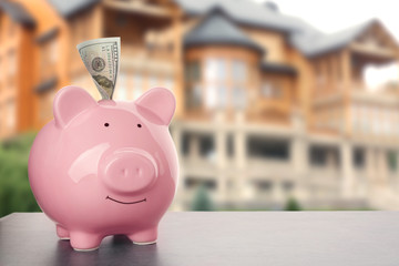 Sticker - Pink ceramic piggy bank with banknote on wooden table