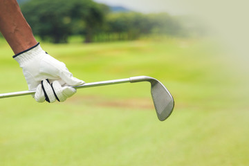 Wall Mural - Golf player holding a golf club on golf course