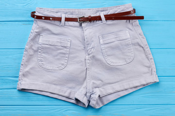 Wall Mural - Modern cotton shorts with belt. Comfortable female summer short pants, blue background.