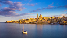 Valletta, Malta - St.Paul's Cathedral In Golden Hour At Malta's Capital City Valletta With Sailboat And Beautiful Colorful Sky And Clouds