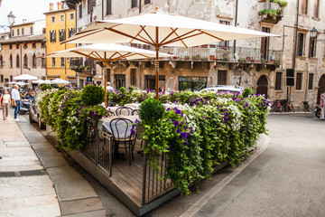 Wall Mural - Verona, Italy  - June 26, 2017: Verona, Italy - Old Cozy outdoor cafe in Verona, Italy, Postcard of Verona streets.