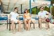 © nazarovsergey - Young people enjoying summer vacation sunbathing drinking at beach bar
