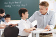 © View Stock - Male teacher helping student study