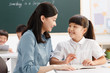 © View Stock - Female teacher helping student studying in classroom