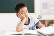 © View Stock - School boy studying with hand on chin