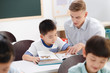 © View Stock - Male teacher teaching students in classroom