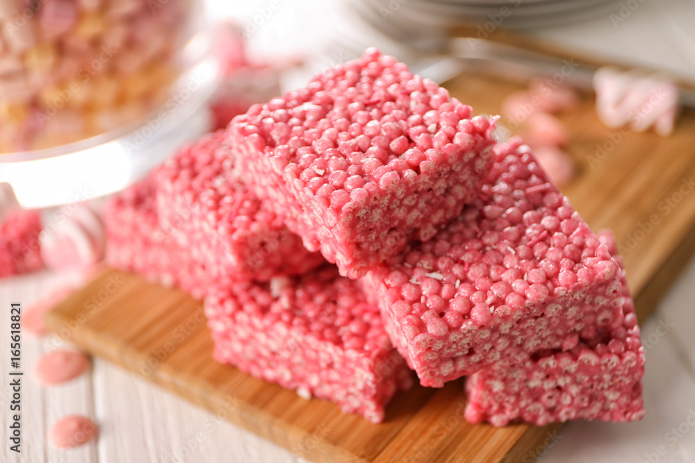 Delicious rice crispy treats on wooden board, closeup