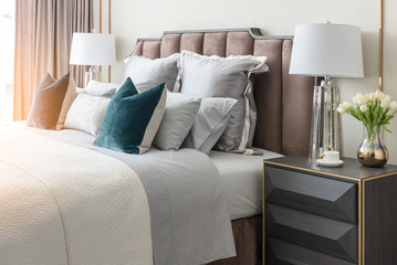 classic bedroom style with set of pillows and lamp on table side