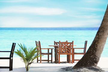 Wall Mural - Table and chairs of beach cafe at resort. Summer vacation concept