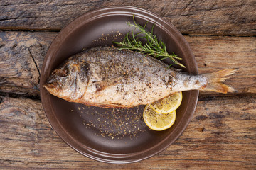 Wall Mural - Seafood eating. Grilled fish on plate from above.