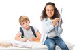 © LIGHTFIELD STUDIOS - adorable multiethnic schoolkids studying together and looking at camera isolated on white