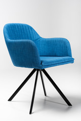 Wall Mural - Studio shot of stylish chair with blue fabric top and triangular metallic legs on white