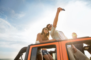 Wall Mural - Happy young friends taking selfie during a road trip