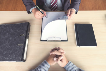 Wall Mural - Job interview, Young attractive executives man reading his resume, work history of applicant in a clipboard, colloquy dream,  Skill, expertise, experience and businessman listen to candidate answers