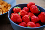 Fototapeta Miasta - Delicious strawberry in a cup on a wooden desk.