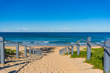 Seascape Of Beach Entrance With Wooden Rails And Sand Shore
