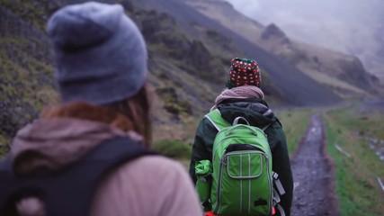 group of young people with backpacks walking through the footpath. friends hiking in the mountains e